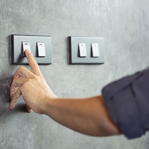 Closeup of a man turning light switch off 