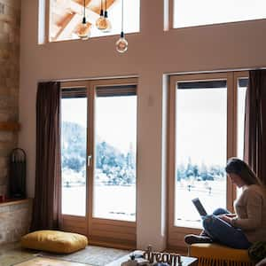 Woman in front of windows with winter scene outside