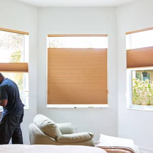 A man installs window blinds