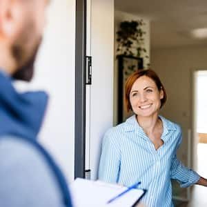 woman and repairman standing in doorway 