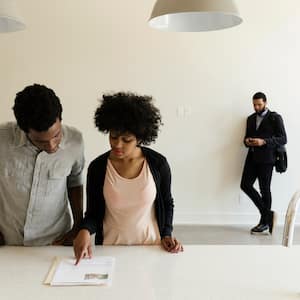 A young couple reading paperwork in a new house