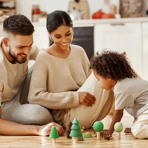 Parents playing with their son on the kitchen floor