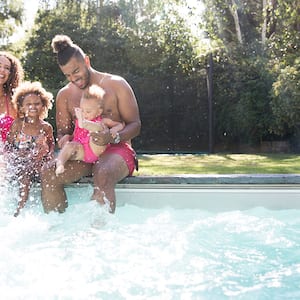 family playing in swimming pool