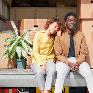 couple sitting in the back of moving truck 