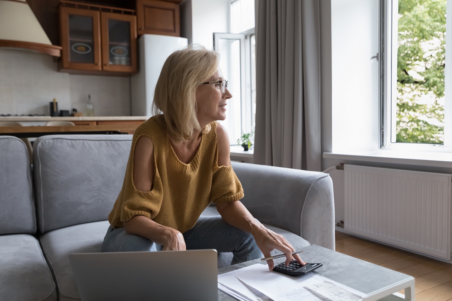 A woman thinking over monthly paperwork