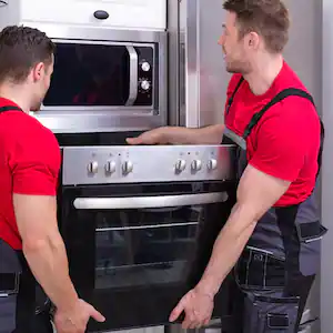 Workers placing modern oven in kitchen