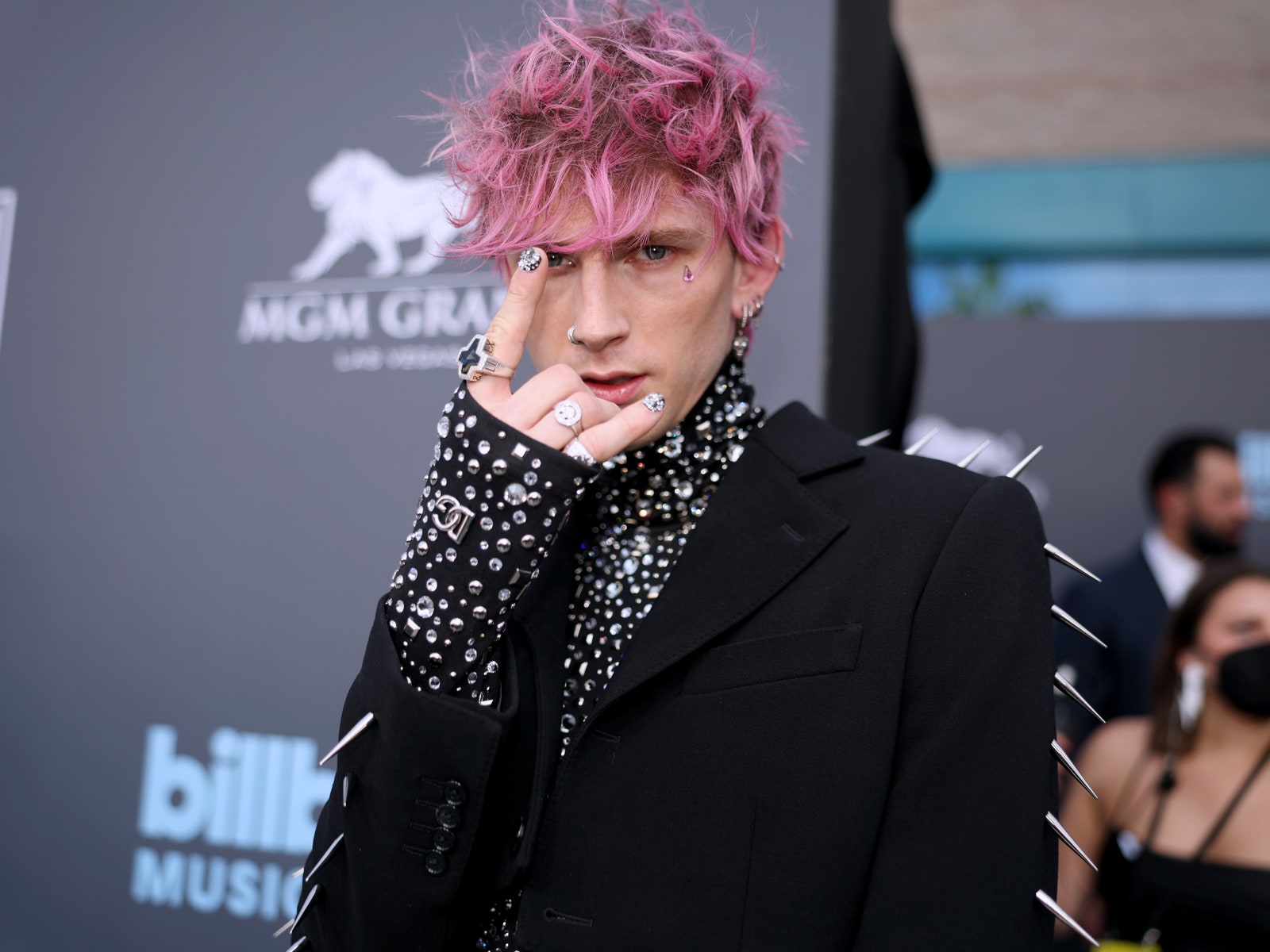 Image may contain Human Person Clothing Apparel Suit Overcoat Coat and Machine Gun Kelly