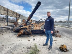 Enno Lenze vor einem zerstörten Panzer