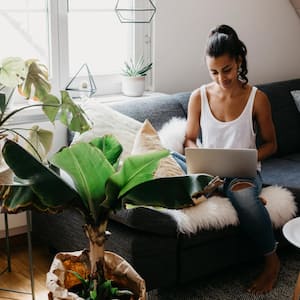  A woman sitting on the couch at home using laptop