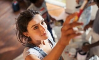 Young woman painting a wall of her home