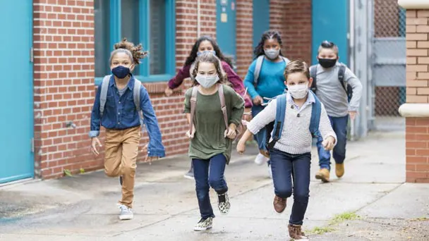 Children wearing masks and backpacks