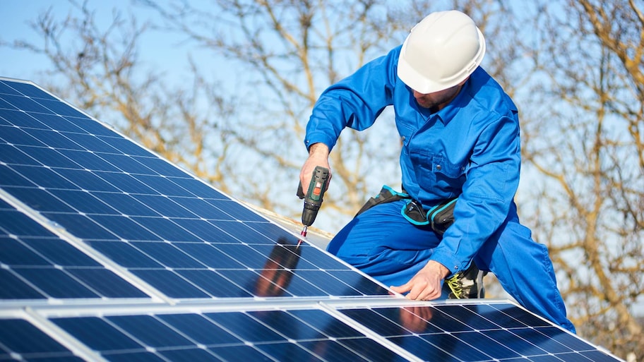 A professional installing solar panels on a house’s roof