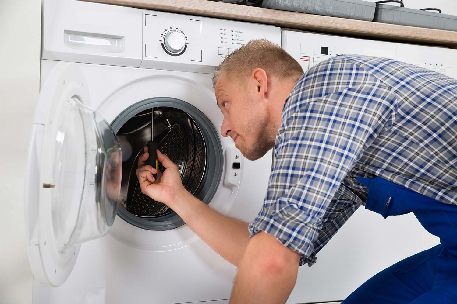 repairman working on washer machine