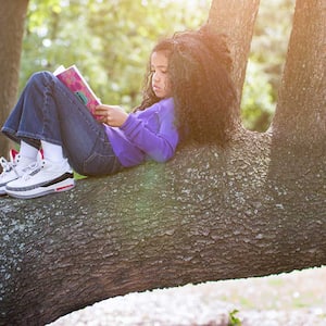 Girl‌ ‌reading‌ ‌book‌ ‌on‌ ‌tree‌ ‌