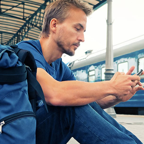 Photo of a person sitting on the ground on their cell phone