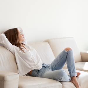 Woman relaxing on white couch in living room