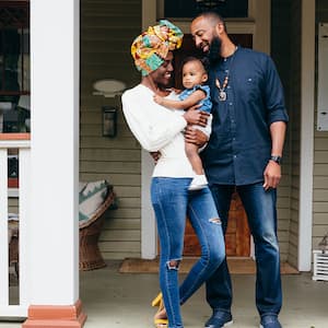 happy family standing outside their home