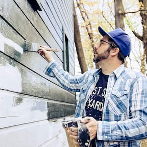 Man painting house with brush