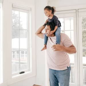 Father carrying daughter on his shoulders at home