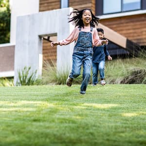 Kids running on grass lawn