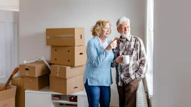 Senior couple at moving day looking through the window