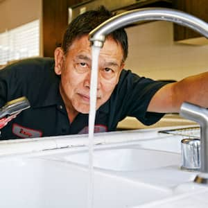 Plumber inspecting water flow