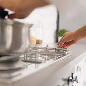 Detail of a woman cooking using a gas stove