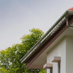 Steel rain gutter with downpipe on the house roof