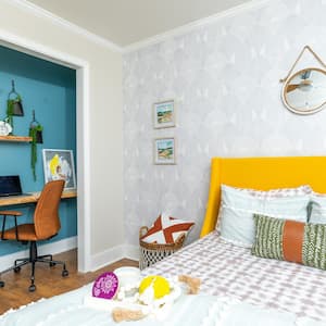 A bedroom with office space and modern bright colors