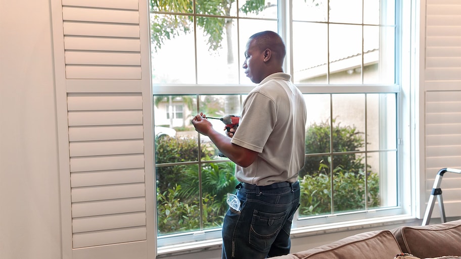 Man installing window treatment