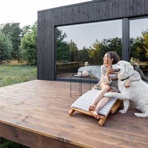 Woman sitting on the deck snuggling with her dog