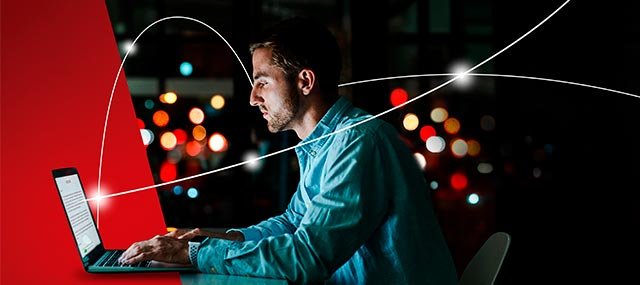 Man working at a laptop with a glowing lines connecting to the world