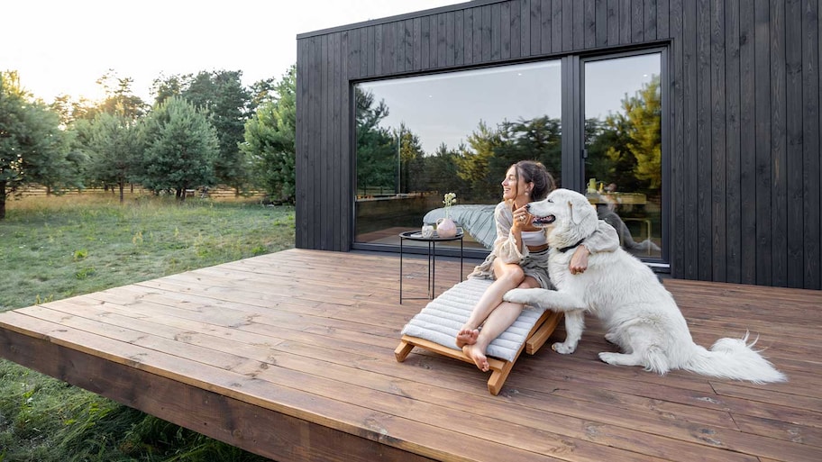 Woman sitting on the deck snuggling with her dog