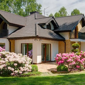 home with backyard and lush flowers and tress       