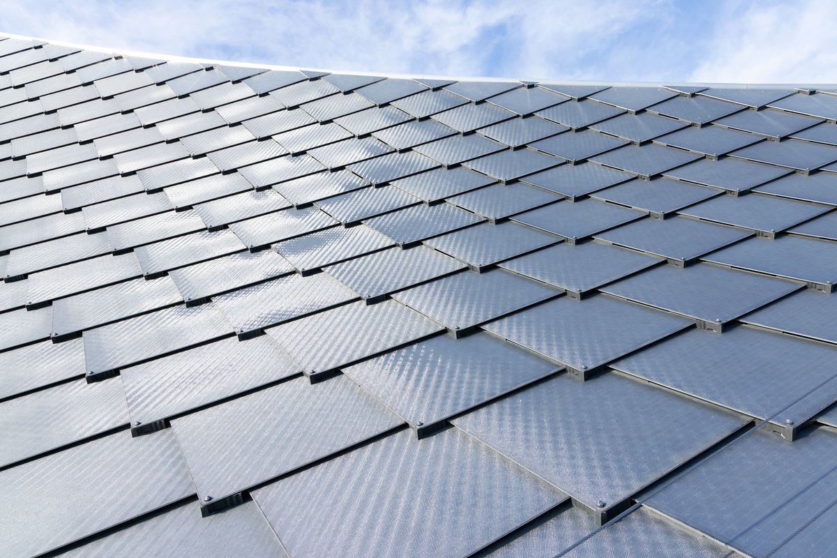 A close-up of the unique solar panels of the "dragonscale" roof at the Google Bay View Campus. The reflective, shiny, diamond-shaped silver panels overlap in a way reminiscent of reptile scales. 