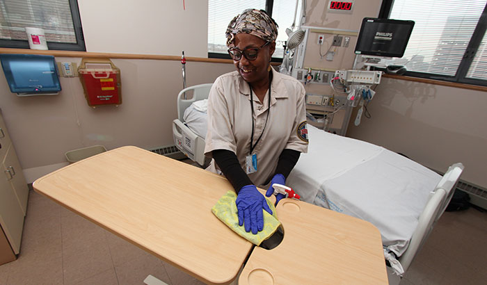 Karen Curtis, with Environmental Services at the Baltimore VA Medical Center, cleans a patient room in the hospital’s intensive care unit. (Photo by Mitch Mirkin)  