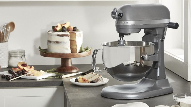 silver kitchenaid mixer on a kitchen counter next to a cake