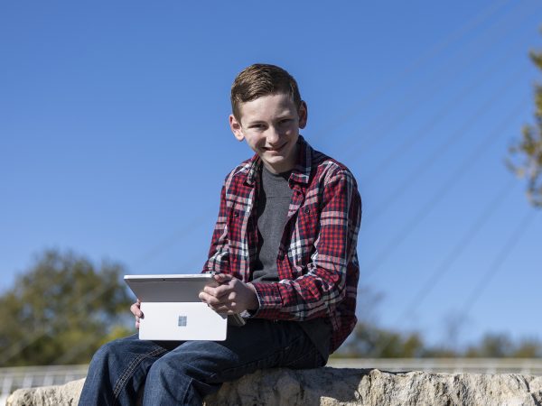 Boy with a laptop near the Keeper of the Plains sculpture in Wichita, Kansas