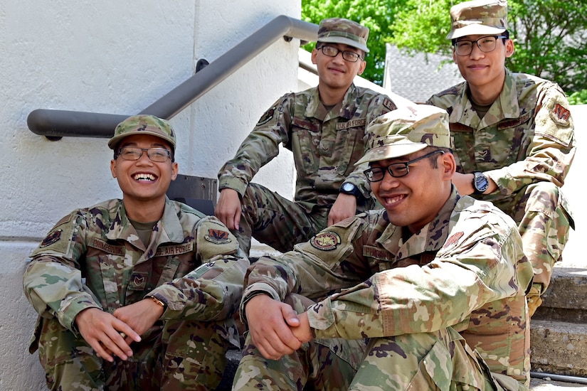 Four airmen sit together on some steps.