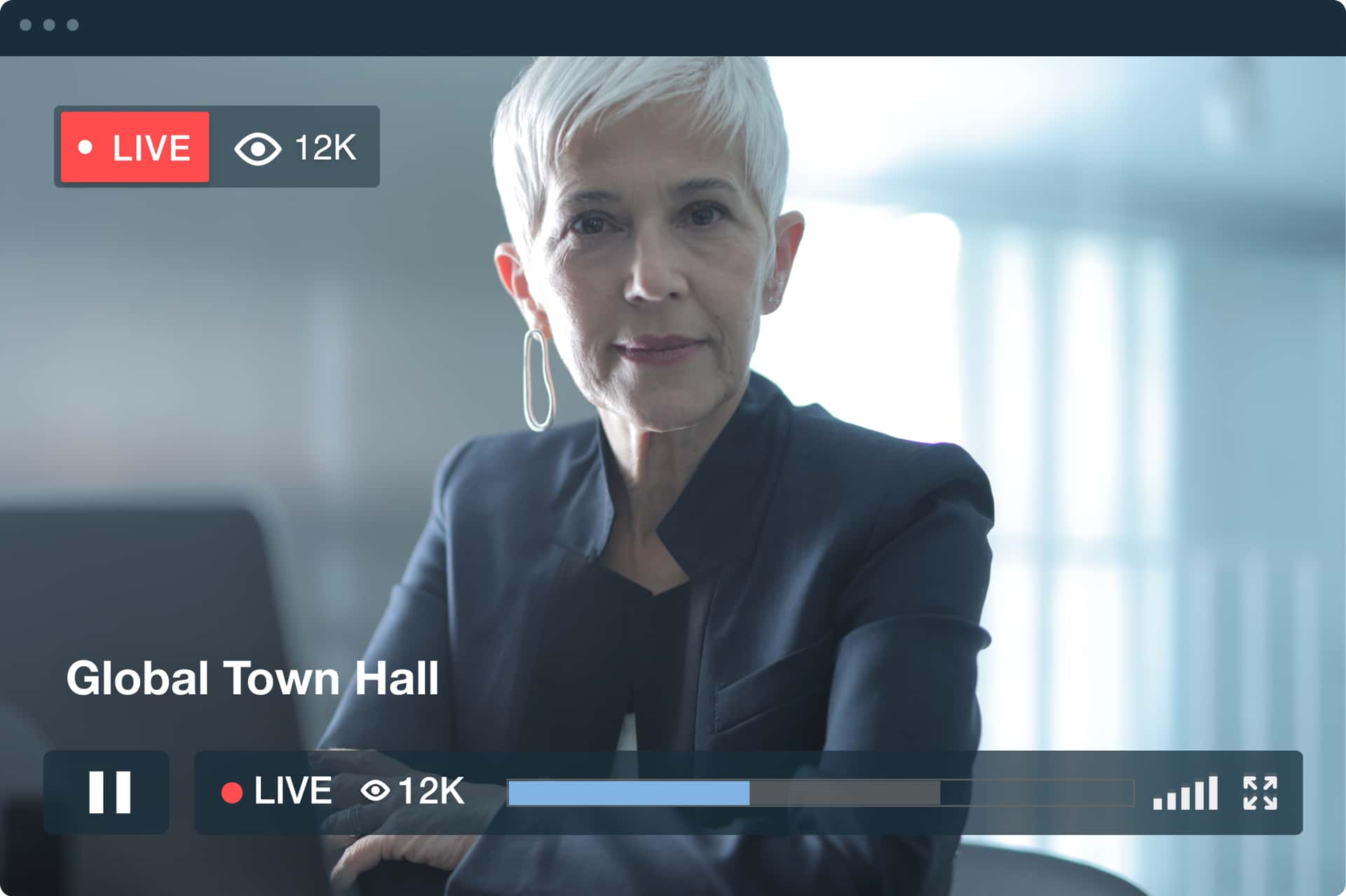 Eine Geschäftsfrau mit weißem Haar und Blazer schaut während eines Live-Meetings in die Kamera.