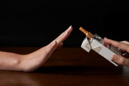 Hand saying no thanks to a packages of cigarettes offered