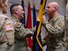 Command Sgt. Maj. Richard Brown passes the 97th Troop Command colors to Col. Tammy Manwaring during the change-of-command ceremony on Camp Williams, Utah, March 13, 2022. Manwaring will then pass the colors on to her successor, symbolically relinquishing her responsibility as the unit's commander. (U.S. Army National Guard photo by Cpl. Alejandro Lucero)