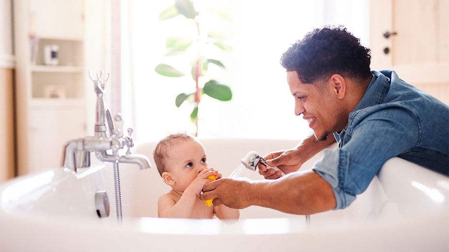 Young father bathing his toddler son