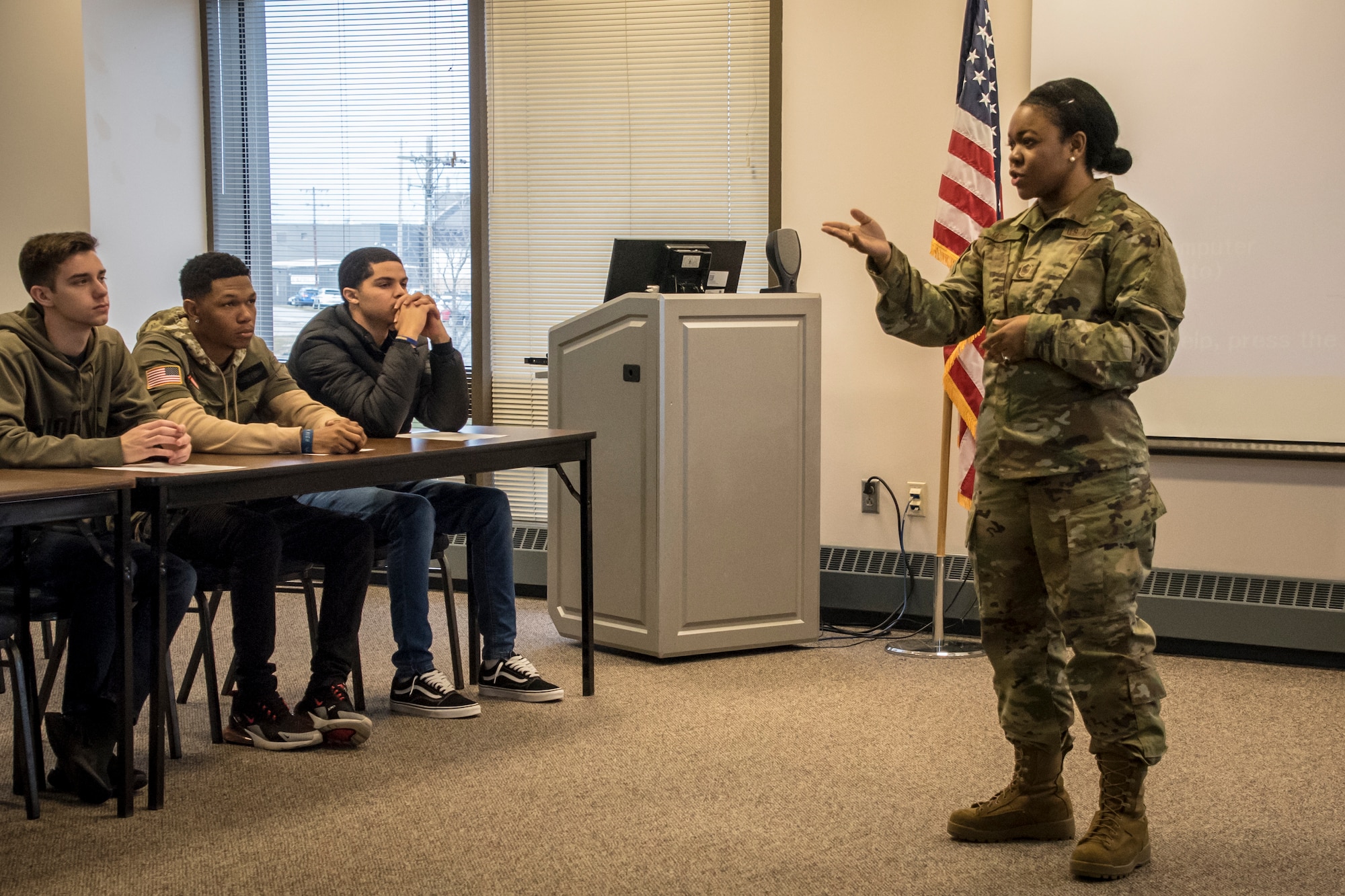 Military member stands at the front of a classroom teaching diversity