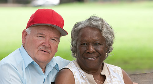 Older couple sitting together on a park bench