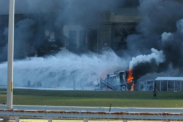 Fire crews work to put out the flames minutes after the attack, 11 September 2001.