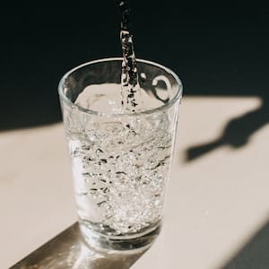 Water being poured in a sunlit glass