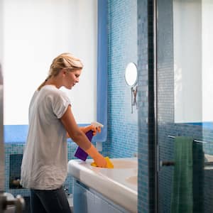 Woman cleaning her blue bathroom