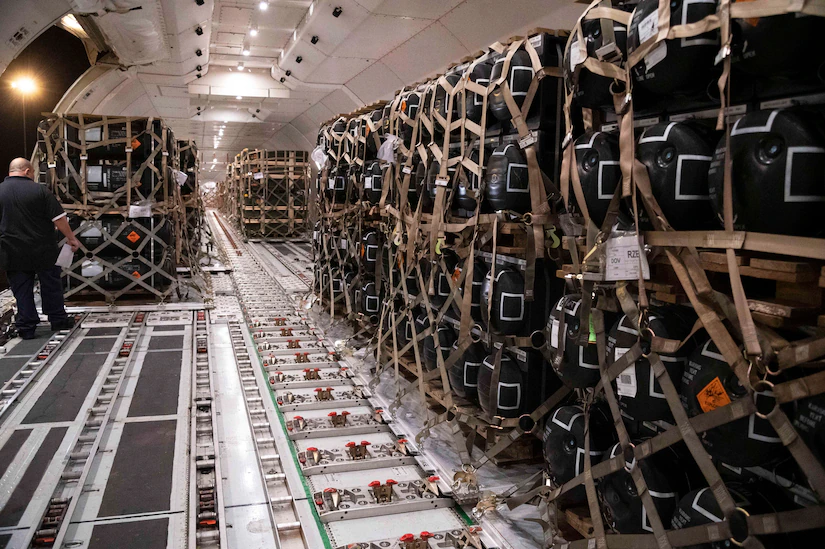 Rows of pallets of cargo sit inside an aircraft.