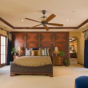 A spacious and luxurious bedroom with a ceiling fan